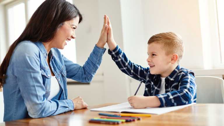 Mom encouraging her son and doing hive five.