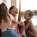 Mother and child laughing together, enjoying a joyful moment.