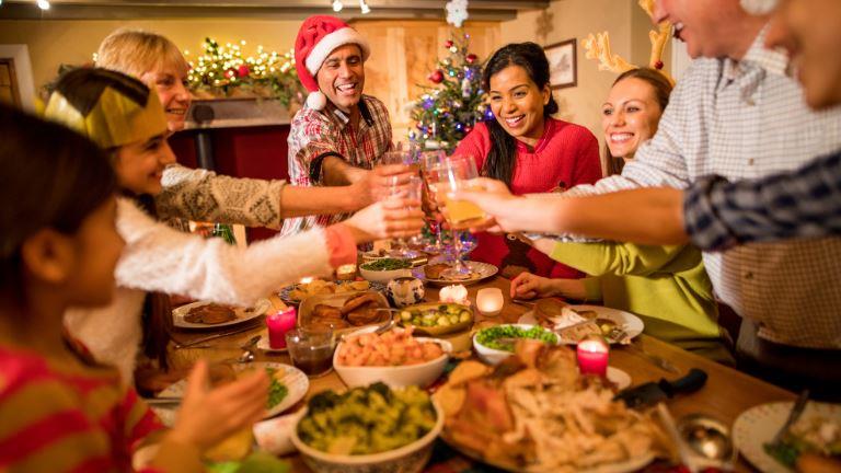 Family gathered around the table for a Christmas dinner, raising glasses in a joyful holiday toast.