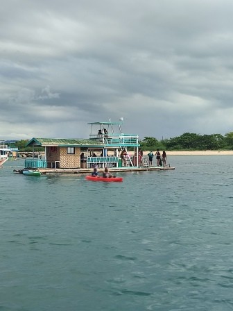 Floating cottage in the middle of the sea, surrounded by calm blue waters, offering a serene and peaceful retreat.